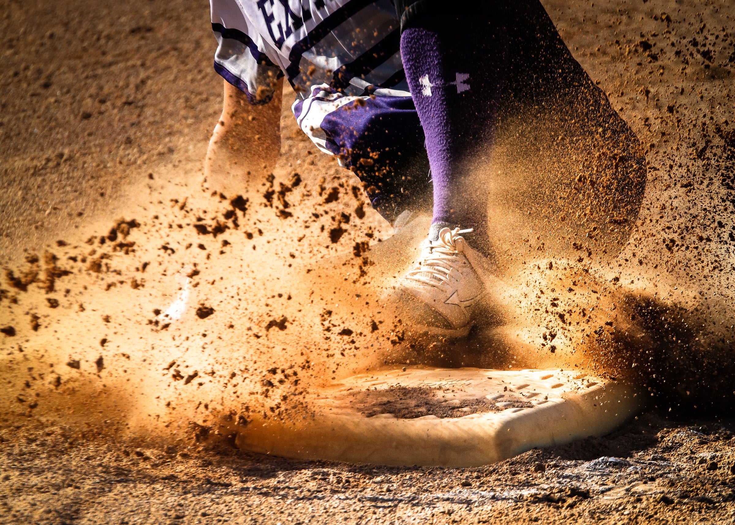 Softball player sliding into base